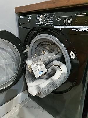 Grey Vetbed dog bedding being washed in a front-loading washing machine.