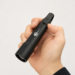 AK-9 multi-function LED torch held in hand, showing compact black aluminium body, side switch and portable size