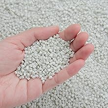 Hand holding white polyester granules used as raw material in the production of Vet fleece bedding.